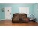 Comfortable living room with wood flooring, a brown leather sofa, and a front door at 2809 49Th N St, St Petersburg, FL 33710