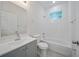 The bright bathroom features a shower over tub, a white vanity and a large, frameless mirror at 2810 N 75Th St, Tampa, FL 33619