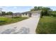 A well-maintained home featuring a gray exterior, a concrete driveway, and a one-car garage at 2810 N 75Th St, Tampa, FL 33619