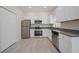 Modern kitchen features stainless steel appliances, white cabinetry, and granite countertops at 2810 N 75Th St, Tampa, FL 33619