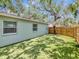 Backyard featuring lush artificial turf, mature trees, and a well-maintained fence for privacy at 2822 W Bay Ave, Tampa, FL 33611