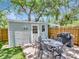 Inviting backyard patio features a light blue shed, outdoor dining set, and barbecue grill for entertaining at 2822 W Bay Ave, Tampa, FL 33611