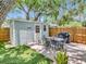 Inviting backyard patio features a light blue shed, outdoor dining set, and barbecue grill for entertaining at 2822 W Bay Ave, Tampa, FL 33611