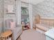 Charming Bedroom features a crib, glider, and floral wallpaper at 2822 W Bay Ave, Tampa, FL 33611