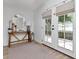 Bright entryway featuring a stylish table, round mirror, and double doors leading to the outside at 2822 W Bay Ave, Tampa, FL 33611