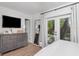 Relaxing main bedroom with backyard access, large dresser, television, and soothing natural light at 2822 W Bay Ave, Tampa, FL 33611