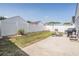 Wide backyard with green grass, an outdoor patio set, grill, umbrella, and a white privacy fence at 30217 Double Dr, Wesley Chapel, FL 33545