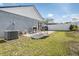 Wide backyard with green grass, an outdoor patio set, grill, umbrella, and a white privacy fence at 30217 Double Dr, Wesley Chapel, FL 33545
