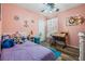 Comfortable bedroom with a unique pink wall, wooden floors, and a decorative fan at 30217 Double Dr, Wesley Chapel, FL 33545