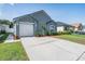 Attractive one-story home with gray exterior, front lawn, and driveway leading to a garage at 30217 Double Dr, Wesley Chapel, FL 33545