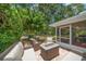 Outdoor patio area offering serene backyard views of a pond and mature trees at 3273 Tanglewood Trl, Palm Harbor, FL 34685