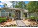 Close up of a home's entrance, beautifully landscaped with mature plants, gravel, stone accents, and a small fountain at 3273 Tanglewood Trl, Palm Harbor, FL 34685
