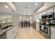Bright kitchen with white cabinetry, stainless steel appliances, and a cozy dining area at 3273 Tanglewood Trl, Palm Harbor, FL 34685