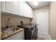 Well-lit laundry room featuring modern washer and dryer, granite countertop, and ample storage space at 3273 Tanglewood Trl, Palm Harbor, FL 34685