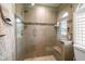 Tiled shower featuring glass door, built-in bench and niche, plus decorative tile accent at 3273 Tanglewood Trl, Palm Harbor, FL 34685