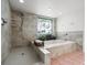 A modern bathroom with a soaking tub, tiled shower, and unique stained glass window at 3305 Westmoreland Dr, Tampa, FL 33618