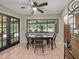 Casual dining area with tile flooring, modern ceiling fan, and view of the screened-in pool area at 3305 Westmoreland Dr, Tampa, FL 33618