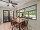 Casual dining area with tile flooring, modern ceiling fan, and view of the screened-in pool area at 3305 Westmoreland Dr, Tampa, FL 33618