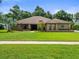 Charming brick home with mature landscaping and a well-manicured lawn at 3305 Westmoreland Dr, Tampa, FL 33618
