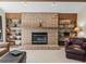 Living room fireplace featuring a brick surround, raised hearth, and built-in shelving and cabinets at 3305 Westmoreland Dr, Tampa, FL 33618