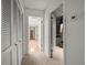 Hallway with multiple closets and doorways leading to other rooms and features neutral colored walls and carpet at 3305 Westmoreland Dr, Tampa, FL 33618