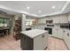 Well-lit kitchen with island, tile floor, modern appliances, and dining area views at 3305 Westmoreland Dr, Tampa, FL 33618