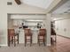 Bright kitchen with white cabinets, breakfast bar with seating, and tiled flooring in adjacent room at 3305 Westmoreland Dr, Tampa, FL 33618