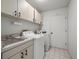 Functional laundry room featuring modern appliances, storage cabinets, and a sink at 3305 Westmoreland Dr, Tampa, FL 33618