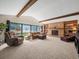 Large living room featuring exposed beams, fireplace with built-ins, and a wall of windows at 3305 Westmoreland Dr, Tampa, FL 33618