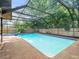 Screened-in pool with clear blue water, attached spa, and a fenced yard at 3305 Westmoreland Dr, Tampa, FL 33618