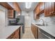 Galley kitchen featuring stainless steel appliances, wood cabinets, and stylish white countertops at 3325 Bayshore Blvd # A17, Tampa, FL 33629