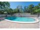 Community pool surrounded by brick pavers with lounge chairs and lush landscaping and a view of high rise at 3325 Bayshore Blvd # A17, Tampa, FL 33629