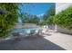 Community pool area with lounge chairs on a brick patio and a clear, blue sky at 3325 Bayshore Blvd # A17, Tampa, FL 33629
