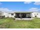 Backyard showcasing the screened porch, and lush grass, providing a serene outdoor space at 4325 93Rd N Ter, Pinellas Park, FL 33782