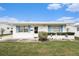 Charming home featuring bright blue shutters, a white exterior, a manicured lawn, and coastal-themed decor at 4325 93Rd N Ter, Pinellas Park, FL 33782