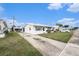 Well-maintained single-story home with a white exterior, features a neatly kept lawn and extended driveway at 4325 93Rd N Ter, Pinellas Park, FL 33782