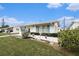 Well-maintained single-story home with a white exterior, features a neatly kept lawn and coastal-themed decor at 4325 93Rd N Ter, Pinellas Park, FL 33782