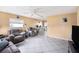 Spacious living room with neutral tones, tile flooring, cozy seating arrangements, and natural light from the windows at 4325 93Rd N Ter, Pinellas Park, FL 33782