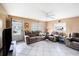 Spacious living room with neutral tones, tile flooring, cozy seating arrangements, and natural light from the windows at 4325 93Rd N Ter, Pinellas Park, FL 33782
