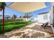 Backyard patio with a shade cover over the chairs, complemented by a lush green lawn and white fencing at 434 77Th Ave, St Pete Beach, FL 33706