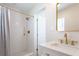 Beautiful bathroom featuring a shower with white tiling and gold hardware, plus marble countertops at 434 77Th Ave, St Pete Beach, FL 33706