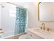 Updated bathroom features stylish vanity, gold fixtures, tiled walls, and a shower with a decorative curtain at 434 77Th Ave, St Pete Beach, FL 33706