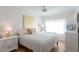 Cozy bedroom with light walls, ceiling fan, wood floors, and natural light from the large window at 434 77Th Ave, St Pete Beach, FL 33706