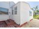 Exterior view of the home with a back door, a wooden deck, and fresh white paint at 434 77Th Ave, St Pete Beach, FL 33706