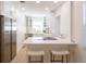 Modern kitchen with white cabinets, stainless steel appliances, and a stylish breakfast bar with seating at 434 77Th Ave, St Pete Beach, FL 33706