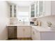 Modern kitchen with white cabinets, stainless steel dishwasher, and stylish gold hardware at 434 77Th Ave, St Pete Beach, FL 33706