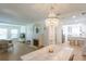 Open-concept living and dining area with a decorative chandelier, fireplace, and view into the bright kitchen at 434 77Th Ave, St Pete Beach, FL 33706