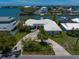 Waterfront home aerial view featuring circle driveway, mature landscaping, and neighborhood waterways at 4545 Clearwater Harbor N Dr, Largo, FL 33770