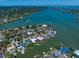Aerial view highlighting waterfront property with docks, pools, and stunning water access for boating and leisure at 4545 Clearwater Harbor N Dr, Largo, FL 33770