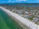 Scenic aerial view of a coastal city with beachfront condos, a sandy beach, and clear ocean waters at 4545 Clearwater Harbor N Dr, Largo, FL 33770